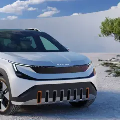 Biały Skoda Enyaq z czarnym dachem i relingami stoi na kamienistym pustkowiu.