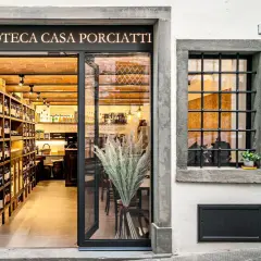 Enoteca Casa Porciatti, sklep z winami w sercu Chianti, zaprasza do degustacji. Wnętrze pełne butelek i ceglanych ścian.