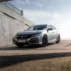 Srebrna Honda Civic 7 na tle betonowej ściany i nieba.