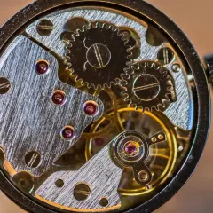Makrofotografia sprzętu zegarka: precyzyjne koła zębate, rubiny i metalowe elementy tworzą skomplikowany mechanizm.