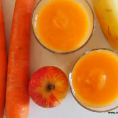Dwa szklanki domowego kubusia z marchewki, jabłka i banana.