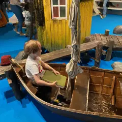 Un bambino legge un libro in una barca, un'installazione interattiva che ricorda Stoccolma con bambini.