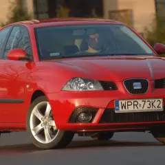 Czerwony Seat Ibiza 3, widok z przodu. Kierowca za kierownicą. Wymiary tego modelu są kompaktowe.