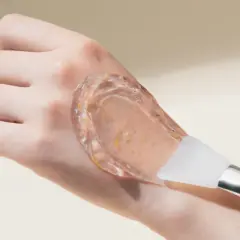 En hand med en genomskinlig gel med små partiklar, appliceras med en spatel. Inga kända peptider biverkningar med denna produkt.