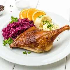 Pieczona kaczka z purée, czerwoną kapustą i pomarańczą. Marynata do kaczki nadała jej złocisty kolor i apetyczny połysk.