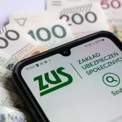 Złotówki i ekran telefonu z aplikacją ZUS. Czy na epilepsję nalezy się renta? Sprawdź w aplikacji ZUS.