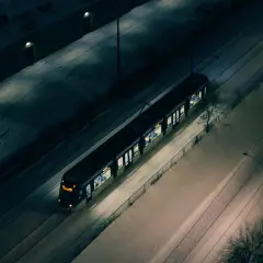Nocny tramwaj w śnieżnej Warszawie, jak jeden z nielicznych autobusów nocnych, przemierza puste ulice.