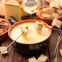 Fonduta cremosa con pane croccante e formaggio svizzero. Gli ingredienti perfetti per una serata conviviale.