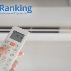Dłoń trzymająca pilot do klimatyzacji, na tle białego urządzenia i logo "Ranking Najlepsze w Trójmieście".
