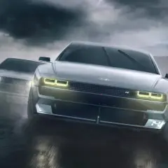 Dwa Hyundai N Vision 74 pędzą po mokrym torze wyścigowym w deszczu.