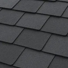 Close-up of dark grey, textured recycled shingles on a roof, showcasing their layered pattern and durable appearance.
