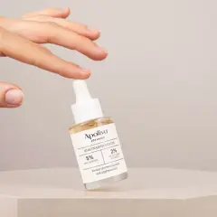 En hand håller en flaska Apoliva Niacinamid Serum, en viktig del av din niacinamide hudvård för en jämnare hy.