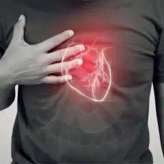 Dłoń na klatce piersiowej, nad nią rysunek serca z czerwonym pulsującym obszarem. Może to symbolizować tamponadę serca.