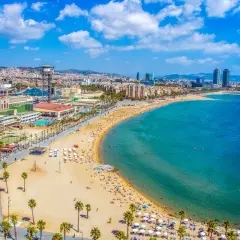 Vista aérea de la playa de la Barceloneta, una de las mejores playas de Barcelona, con gente disfrutando del sol y el mar.