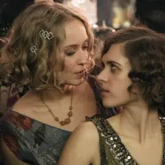 Zwei Frauen im Stil der 1920er Jahre, eine mit blonden Locken und Schmuck, die andere mit dunklen Locken, blicken sich intensiv an. Ein Moment aus Babylon Berlin Staffel 5.