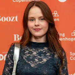Andrea Heick Gadeberg ler mot kameran framför en orange bakgrund med texten "Vild med dans" och "Spring Copenhagen".