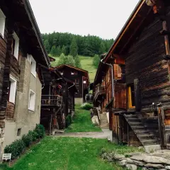 Tradycyjne drewniane domy w górskiej wiosce, przypominające skansen.
