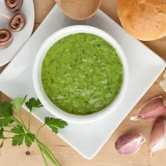 Salsa verde ricetta: prezzemolo fresco, aglio, acciughe arrotolate e pane croccante, ingredienti per un sapore intenso.