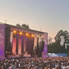 Große Menschenmenge feiert beim Stadt ohne Meer Festival. Die Elefantenklo Stage ist beleuchtet, Quallen-Deko schwebt in der Luft.