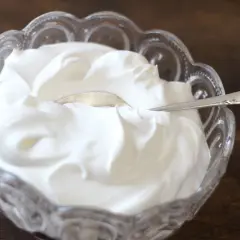 Gęsta, biała śmietana w kryształowej miseczce. Czy to creme fraiche? Tak, to właśnie creme fraiche, idealna do deserów i sosów.