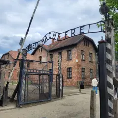 Brama z napisem "Arbeit Macht Frei" prowadzi do budynków obozu Auschwitz.