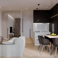 Nowoczesny salon z kuchnią. W salonie biała kanapa, czarny telewizor na ozdobnej ścianie. W kuchni czarne szafki, wyspa, stół z krzesłami. Taśma LED nad kanapą świeci najmocniej.
