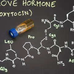 Struktura chemiczna oksytocyny, hormonu miłości, obok fiolki z płynem.