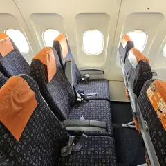 Puste siedzenia w samolocie easyJet, gotowe na pasażerów po odprawie online.