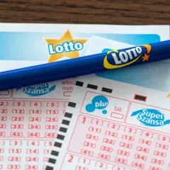 Niebieski ołówek na kuponach Lotto z zaznaczonymi polami do wyboru liczb.