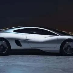 Elegancki, srebrny, nowy jaguar o futurystycznym designie, z wąskimi światłami LED i aerodynamiczną sylwetką, stoi na mokrej nawierzchni.