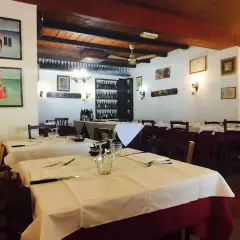 Interno di uno dei ristoranti di Ferrara, con tavoli apparecchiati e quadri alle pareti.