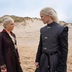 Rhaenyra i Daemon Targaryenowie, bohaterowie "Ród smoka", stoją na piaszczystej plaży, wpatrzeni w siebie.