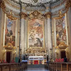 Interno della chiesa di Sant'Ignazio di Loyola, con affreschi barocchi, altare dorato e panche in legno.