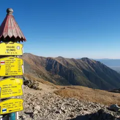 Grześ Rakoń na Volovcu, szczycie o wysokości 2063 m n.p.m. w Tatrach. Znaki wskazują szlaki na Jamnickie Sedlo, Ostry Roháč i inne.