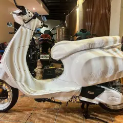 Vespa bianca personalizzata con fiamme, un vero gioiello a 2 tempi pronto a sfrecciare.
