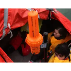 Arancione transponder navi SART McMurdo in una zattera di salvataggio con persone con giubbotti di salvataggio.