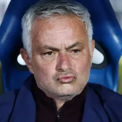 Jose Mourinho, były trener Realu Madryt, siedzi na ławce rezerwowych, zamyślony.