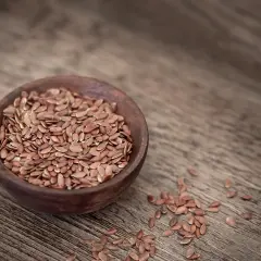 Braune Leinsamen in einer Holzschale, bereit, um leinsamenmehl selber machen zu können.
