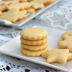 Deliciosas galletas caseras en forma de estrella y muñeco, apiladas en un plato blanco.