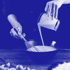 Manos mezclando diferentes tipos de leche en un bol. Huevos rotos y harina en la mesa.