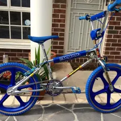 A blue Mongoose Supergoose BMX bike, a classic from the 1980s bicycle brands, with chrome accents and blue mag wheels.