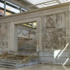 L'Ara Pacis, un capolavoro in marmo, mostra rilievi storici e decorativi. Le sue scalinate conducono a un altare antico, testimone di un'epoca passata.