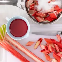 Frischer Rhabarber wird geschnitten und mit Zucker für ein leckeres Rhabarberkompott vorbereitet.