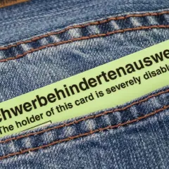 Schwerbehindertenausweis in Jeans-Tasche. Der Ausweis bestätigt den Grad der Behinderung, z.B. bei Herzschrittmacher-Trägern.