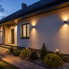 Eleganckie oświetlenie elewacji domu parterowego tworzy przytulną atmosferę.