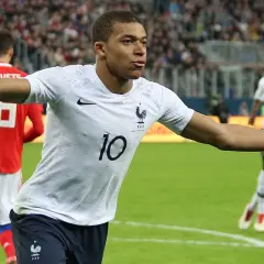 Kylian Mbappé w białej koszulce z numerem 10, świętuje bramkę. Jego waga jest idealna do szybkich sprintów.