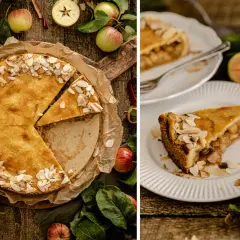 Ein goldbrauner gedeckter Apfelkuchen, bestreut mit Mandelblättchen, wird auf einem Holztisch präsentiert. Daneben liegen frische Äpfel und Blätter.