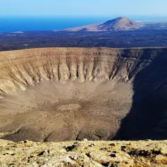 Ogromna kaldera wulkaniczna, co to jest? Pustynny krajobraz z morzem w tle.