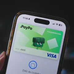Jak dodać kartę do telefonu? Na ekranie smartfona widać aplikację PayPo z wirtualną kartą Visa i instrukcją zbliżenia do czytnika.