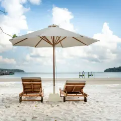 Dwie leżaki pod parasolem na piaszczystej plaży. Idealna pogoda na Korfu w czerwcu, błękitne niebo z chmurami, spokojne morze.